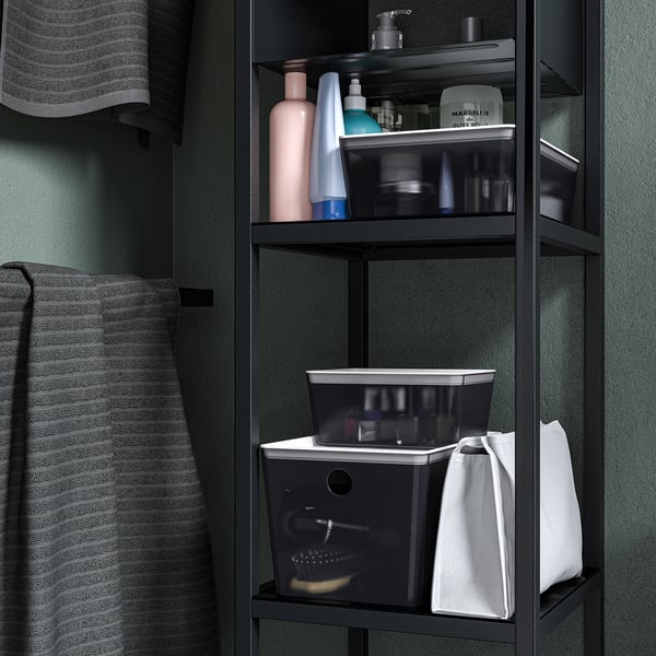 Boîte de rangement noire sur l’étagère de la salle de bain pour ranger les articles de toilette. Fait partie de la série KUGGIS, s’empile avec couvercle.