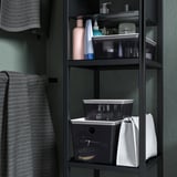 Boîte de rangement noire sur l’étagère de la salle de bain pour ranger les articles de toilette. Fait partie de la série KUGGIS, s’empile avec couvercle.