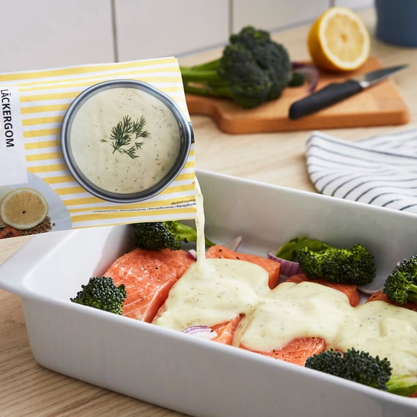 Saumon et brocoli avec sauce crémeuse au citron dans un plat. Couteau et citron à proximité.