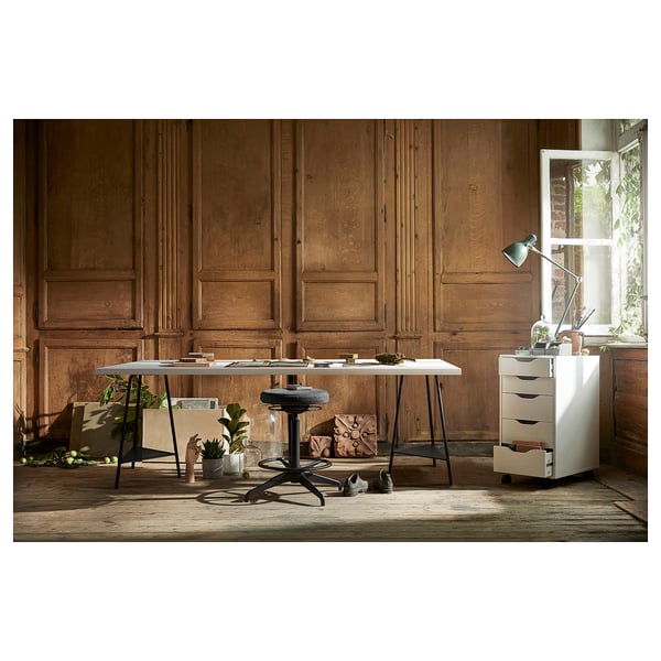 Configuration du bureau à domicile : bureau blanc, chaise noire, plantes, lampe sur les murs en bois.