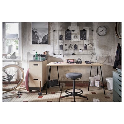 Chambre de style industriel avec bureau en bois et tabouret noir, vélo suspendu et horloge murale.