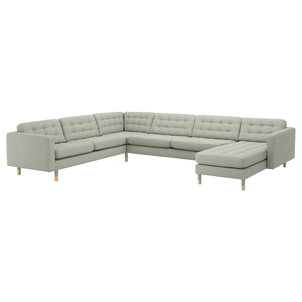 Canapé sectionnel moderne, gris clair, en forme de L avec dossier et coussins d’assise capitonnés, pieds en bois.