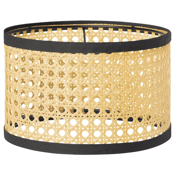 Abat-jour LÅNGSKEPPS : texture tissée naturelle, forme ronde avec bordure noire, émet un éclairage chaud.