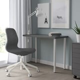 Bureau à domicile minimaliste avec bureau LINNMON, chaise, lampe et impressions d’art.