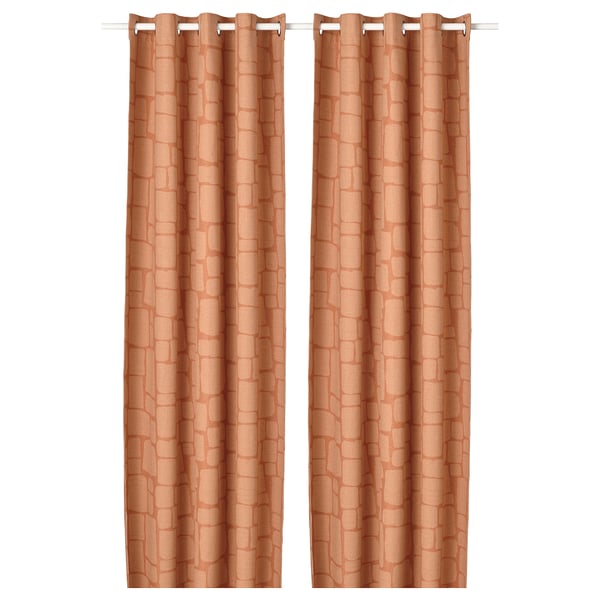 Les rideaux orange LÖNNSTÄVMAL, texturés, assortis avec dessus à œillets, bloquent la lumière.