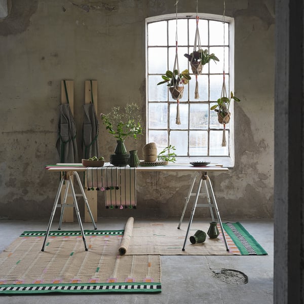 Cintres et décoration en macramé dans une pièce rustique et confortable avec de grandes fenêtres.