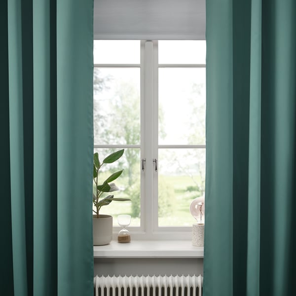 Fenêtre avec rideaux turquoise foncé, œillets pour un glissement en douceur, intimité. Décor : plante et vases.