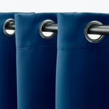 Rideaux occultants bleus avec œillets sur tige d’argent, montrés suspendus.