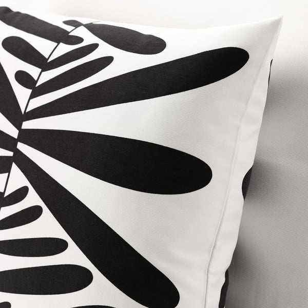 Coussin motif feuille noire et blanche. Housse en coton doux avec fermeture à glissière. Design moderne.