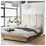 Lit en bois moderne MANDAL avec tiroirs, literie noire et blanche, design épuré.