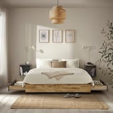 Scène de chambre avec lit MANDAL, couvertures blanches, plate-forme en bois naturel. Œuvre d’art sur mur, grande suspension. Couleurs légères et aériennes, design minimaliste.