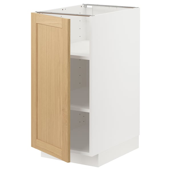 Un meuble de cuisine METOD ouvert avec une porte en placage de chêne clair. Il s’agit d’un cadre blanc et d’étagères réglables.