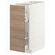 Une armoire de cuisine METOD blanche avec une porte à motif de bois clair brokhult s’est ouverte, révélant des étagères réglables à l’intérieur.