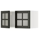 Armoires de cuisine noires et blanches avec portes vitrées. Une porte est ouverte, révélant des étagères intérieures. Le design est moderne et épuré.