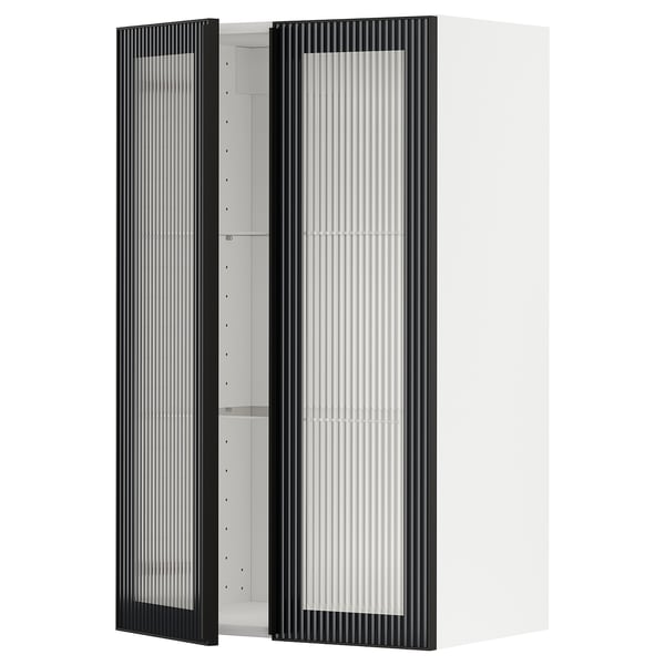Une armoire murale de cuisine METOD blanche avec une porte en verre hejsta noir avec verre cannelé et cadres en métal avec poignées intégrées.