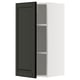 Armoire de cuisine en noir et blanc. La porte ouverte révèle l’étagère à l’intérieur.
