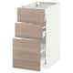 Une armoire de cuisine METOD blanche avec trois tiroirs ouverts à motifs en bois brun clair.