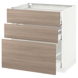 Cette image représente une armoire de cuisine METOD blanche avec trois tiroirs en grain de bois clair. Le design des tiroirs à fermeture automatique et une esthétique simple et moderne.
