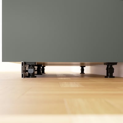 Deux pieds de meubles réglables noirs, chacun avec une base ronde, un cylindre et des boutons réglables, conçus pour la stabilité sur les sols inégaux.