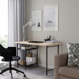 Bureau à domicile minimaliste : bureau MITTCIRKEL, chaise noire, imprimé zèbre, lampe, canapé et coussins.