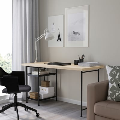 Un bureau à domicile moderne avec bureau MITTCIRKEL, vue sur la fenêtre, chaise noire et siège confortable. Le bureau peut contenir un ordinateur portable, une lampe et des fournitures. L’art minimaliste ci-dessus.