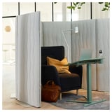 Espace de travail à écran acoustique. Configuration moderne avec des cloisons grises, une chaise noire, un bureau vert et un ordinateur portable.