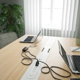 Table de conférence avec ordinateurs portables, plante. Idéal pour les réunions, le coworking.