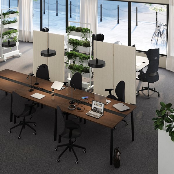 Bureau moderne : tables de conférence en bois MITZZON, cloisons beiges, chaises et lampes noires. Des postes de travail spacieux, fonctionnels et bien organisés.