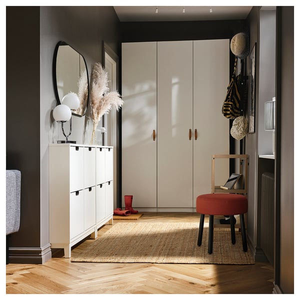 Entrée modulaire avec rangement blanc, miroir, tabouret rouge, manteaux et bottes.