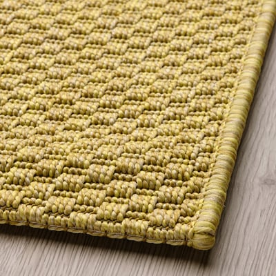 Un tapis MORUM en beige, rectangulaire, avec un motif tissé à plat, en polypropylène.