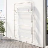 Séchoir en métal blanc sur le balcon, adapté pour le linge de lit et les serviettes, plis pour le rangement.