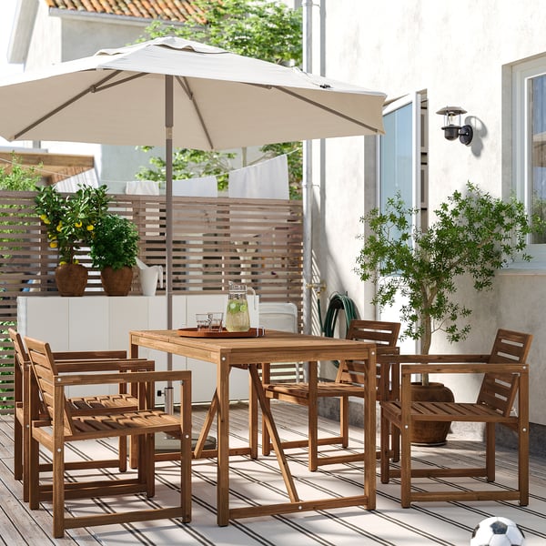 Ensemble de salle à manger d’extérieur NÄMMARÖ avec table, 4 chaises, parasol et boissons sur le pont.