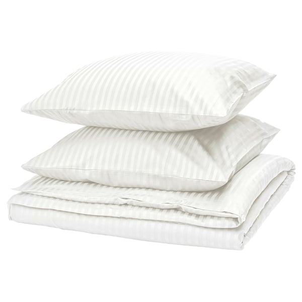 Ensemble de literie NATTJASMIN : blanc, satin rayé, coton/lyocell, empilement soigné.