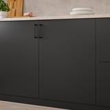 Cuisine moderne avec des armoires gris foncé, des poignées élégantes et des assiettes empilables. Finition noir mat pour un look élégant.