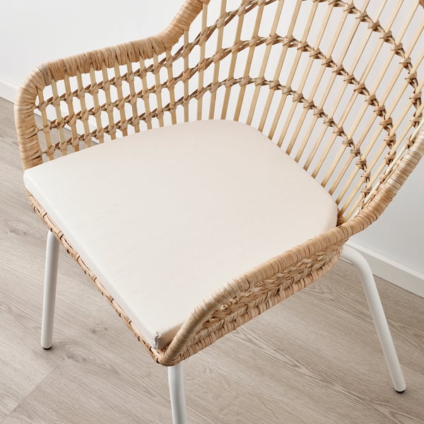 Fauteuil en rotin tressé et bambou, coussin crème, léger, élégant, robuste, confortable, aspect naturel.