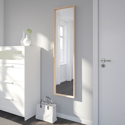 Un miroir NISSEDAL avec un cadre rectangulaire de couleur marron clair. Le miroir peut être suspendu verticalement ou horizontalement et a un design minimaliste.