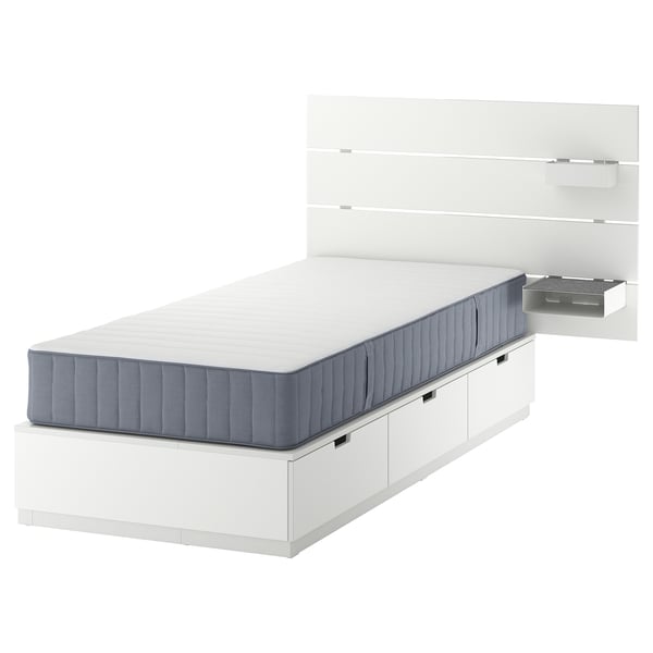 Lit NORDLI, blanc, avec matelas bleu-gris, tiroirs, étagère murale, design minimaliste moderne.