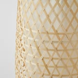Gros plan d’un abat-jour en bambou tissé à la main, mettant en valeur un savoir-faire complexe et une texture naturelle.