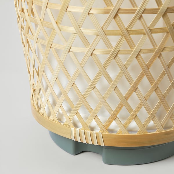 Lampadaire en bambou tissé à la main avec un design en treillis complexe, avec des variations de couleurs naturelles et un savoir-faire de qualité.