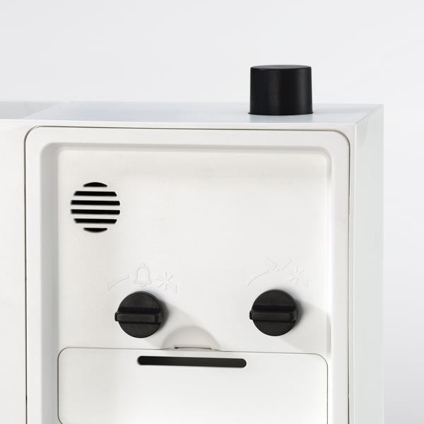 Gadget blanc avec boutons noirs, haut et devant, design élégant, matériaux de qualité.