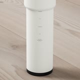 Pied de table réglable moderne, hauteur 60-90cm, blanc avec base noire, posé sur un sol en bois.