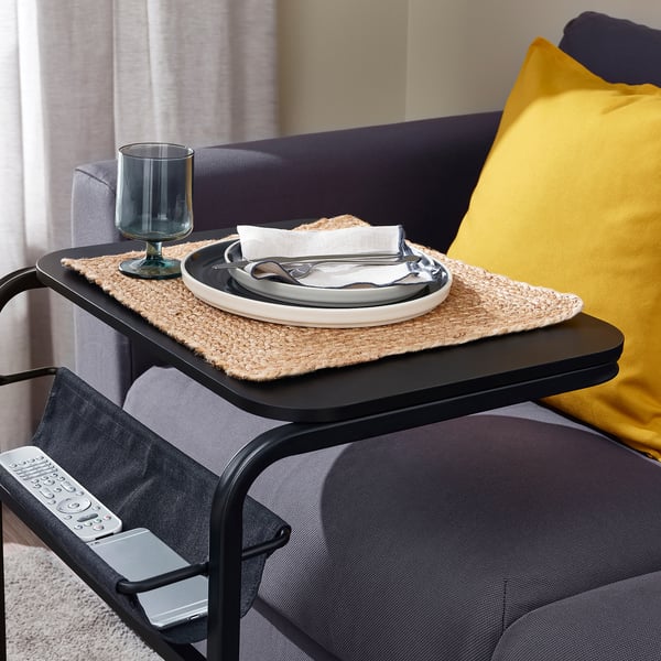 Une table d’appoint multifonctionnelle avec un plateau qui glisse sur les genoux, parfaite pour manger tout en regardant la télévision. La pochette attachée peut contenir la télécommande et le téléphone.