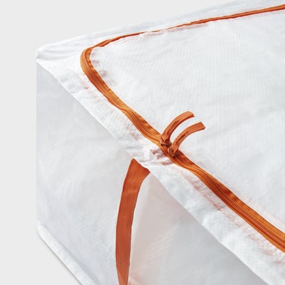 Un sac de rangement PÄRKLA blanc avec fermeture éclair et poignées orange, de forme carrée, fabriqué à partir de matériaux recyclés.