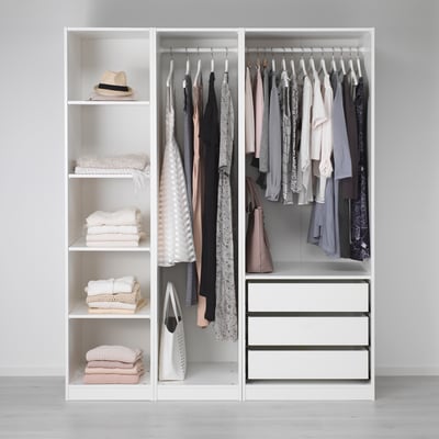 Armoire minimaliste avec vêtements, serviettes et tiroirs de rangement.