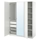 Une armoire PAX blanche ouverte avec plusieurs compartiments de rangement, des tiroirs et un miroir.