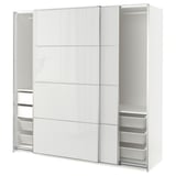 Une armoire ikea PAX blanche avec des portes en verre. Il s’agit d’un design moderne avec des portes coulissantes, des paniers en maille métallique et des étagères spacieuses à l’intérieur.
