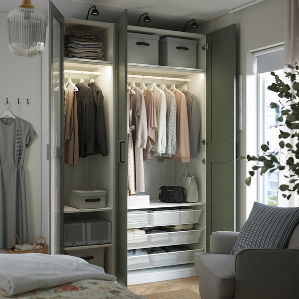 Armoire ouverte avec vêtements, accessoires et rangements. Les portes en miroir agrandissent l’espace. L’éclairage intégré éclaire le contenu.