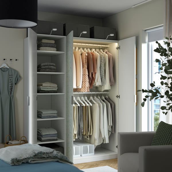 Placard organisé avec étagères et cintres. Les vêtements sont soigneusement rangés, mettant en valeur une solution de rangement fonctionnelle.