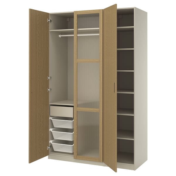 Une armoire PAX en chêne clair avec des portes ouvertes, avec des étagères et des tiroirs à l’intérieur.