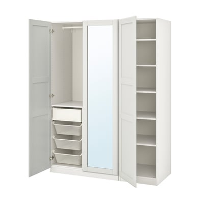 Une armoire IKEA PAX blanche ouverte avec des étagères, un miroir et des paniers en filet.